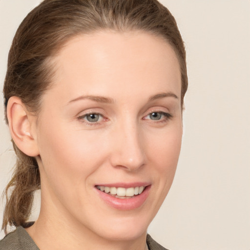 Joyful white young-adult female with short  brown hair and grey eyes