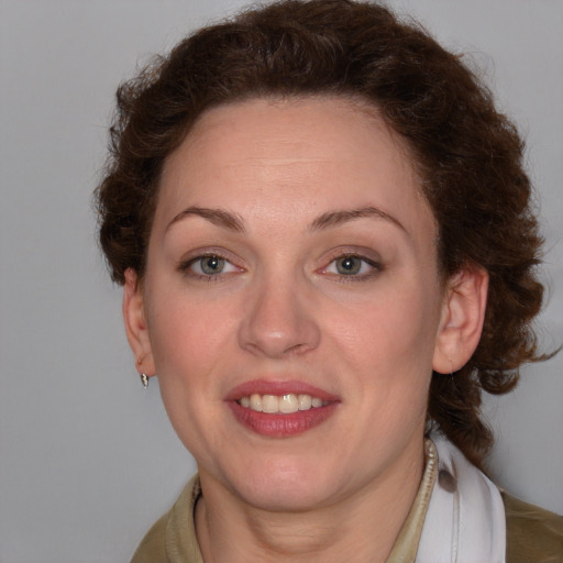 Joyful white young-adult female with medium  brown hair and blue eyes