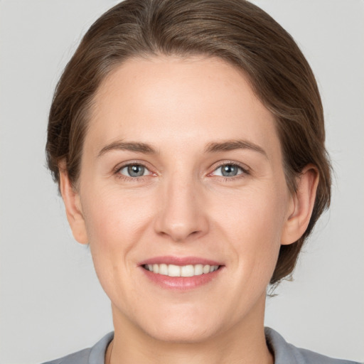 Joyful white young-adult female with medium  brown hair and grey eyes