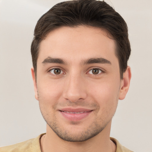 Joyful white young-adult male with short  brown hair and brown eyes