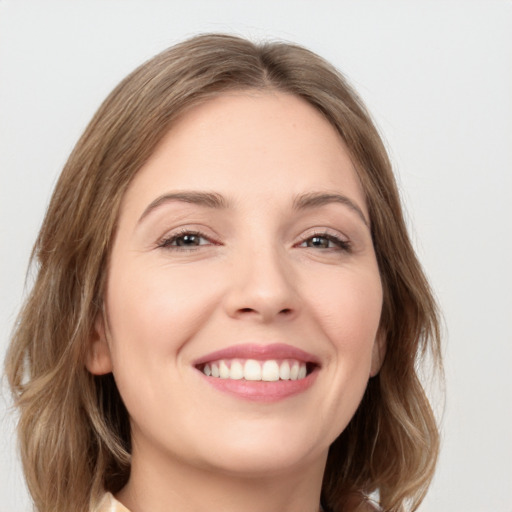 Joyful white young-adult female with medium  brown hair and green eyes