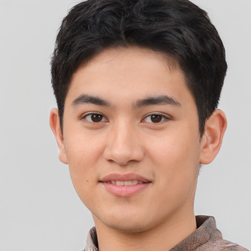 Joyful asian young-adult male with short  brown hair and brown eyes