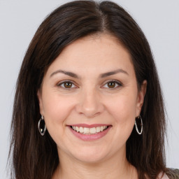 Joyful white young-adult female with long  brown hair and brown eyes