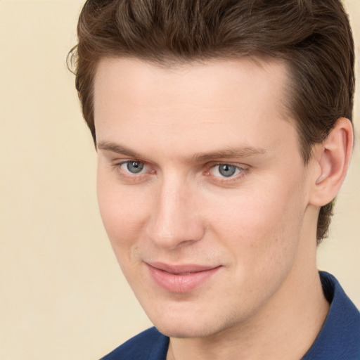 Joyful white young-adult male with short  brown hair and grey eyes