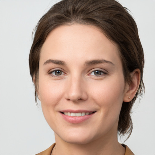 Joyful white young-adult female with medium  brown hair and grey eyes