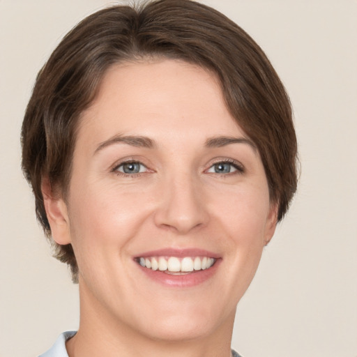 Joyful white young-adult female with short  brown hair and grey eyes