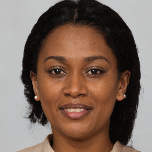 Joyful black adult female with medium  brown hair and brown eyes