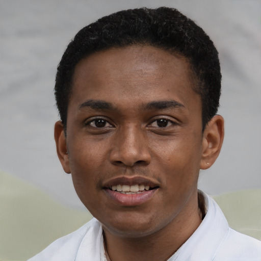 Joyful black young-adult male with short  brown hair and brown eyes