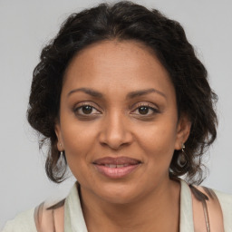 Joyful black adult female with medium  brown hair and brown eyes