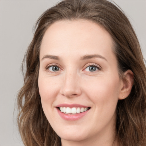 Joyful white young-adult female with long  brown hair and grey eyes