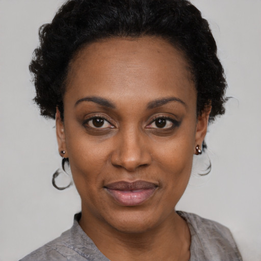 Joyful black young-adult female with short  black hair and brown eyes