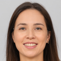 Joyful white young-adult female with long  brown hair and brown eyes