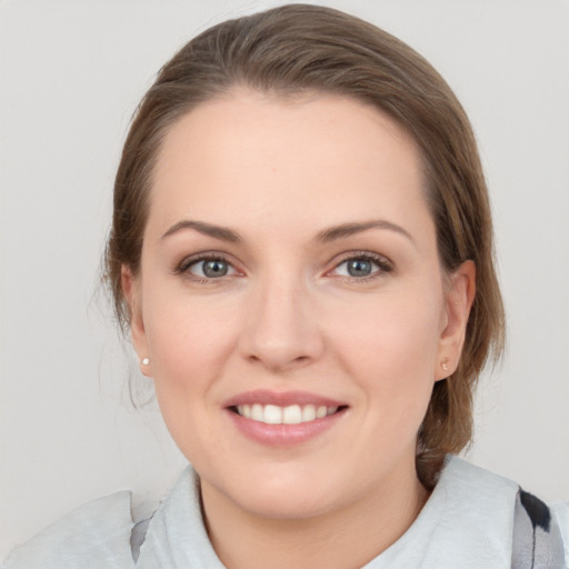 Joyful white young-adult female with medium  brown hair and grey eyes