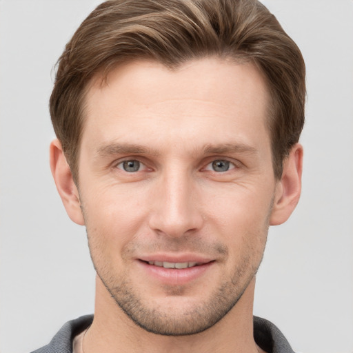 Joyful white young-adult male with short  brown hair and grey eyes