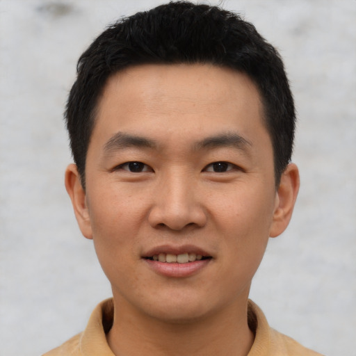 Joyful asian young-adult male with short  brown hair and brown eyes