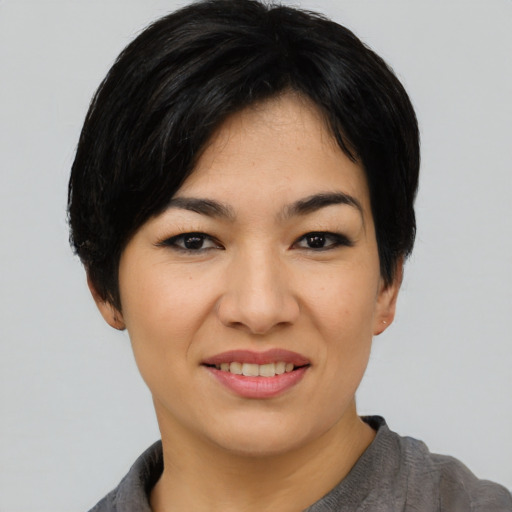 Joyful asian young-adult female with short  black hair and brown eyes