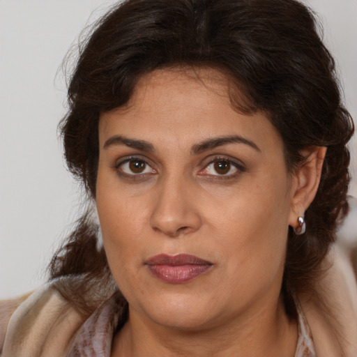 Joyful latino adult female with medium  brown hair and brown eyes