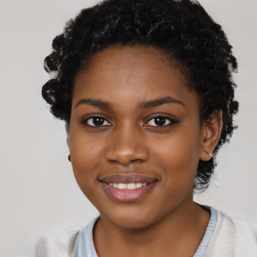 Joyful black young-adult female with short  black hair and brown eyes