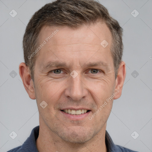 Joyful white adult male with short  brown hair and grey eyes