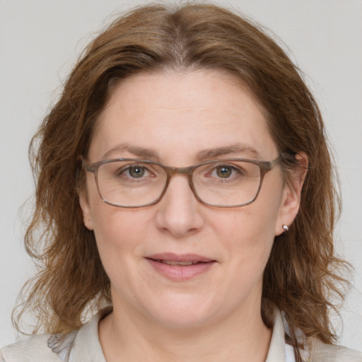 Joyful white adult female with medium  brown hair and blue eyes