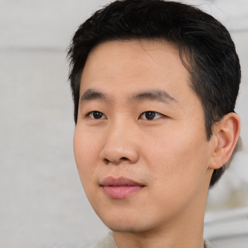 Joyful asian young-adult male with short  black hair and brown eyes