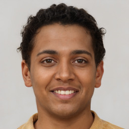 Joyful latino young-adult male with short  brown hair and brown eyes