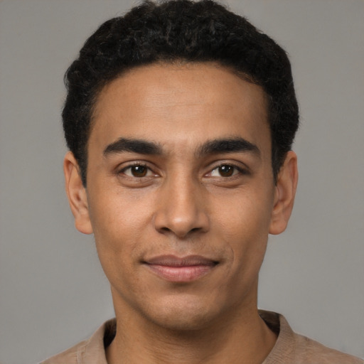 Joyful latino young-adult male with short  black hair and brown eyes