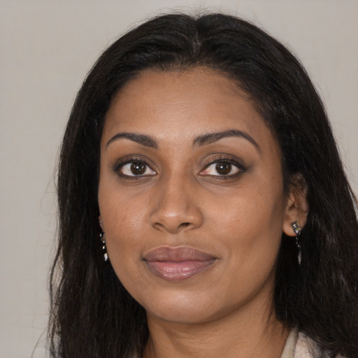 Joyful black young-adult female with long  brown hair and brown eyes