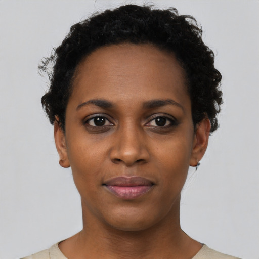 Joyful black young-adult female with short  black hair and brown eyes