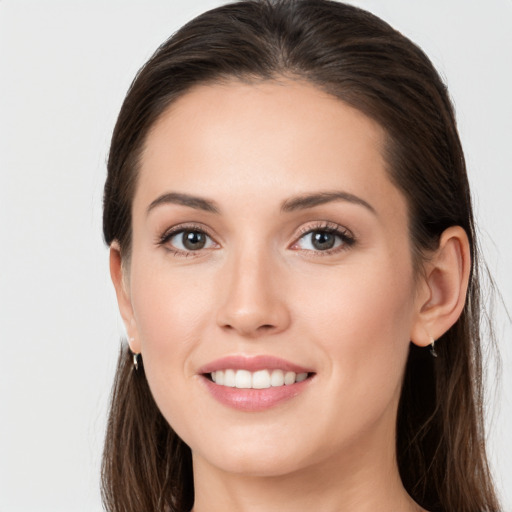 Joyful white young-adult female with long  brown hair and grey eyes