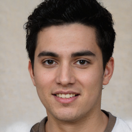 Joyful white young-adult male with short  black hair and brown eyes