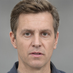 Joyful white adult male with short  brown hair and grey eyes