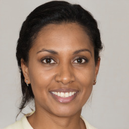 Joyful latino young-adult female with medium  brown hair and brown eyes