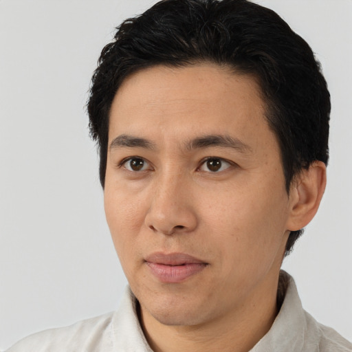 Joyful asian adult male with short  black hair and brown eyes
