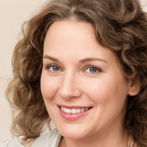 Joyful white adult female with medium  brown hair and green eyes