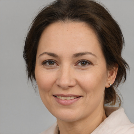 Joyful white adult female with medium  brown hair and brown eyes