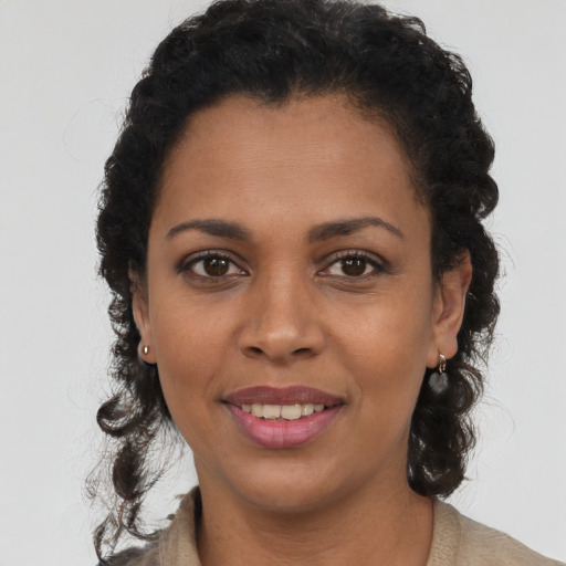 Joyful black young-adult female with long  brown hair and brown eyes
