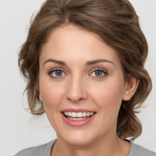 Joyful white young-adult female with medium  brown hair and blue eyes