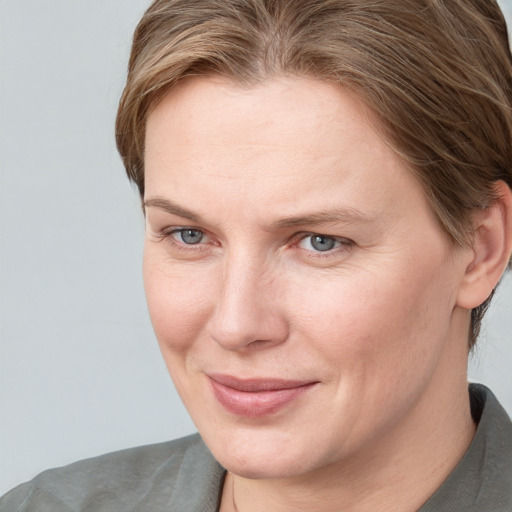 Joyful white adult female with medium  brown hair and blue eyes