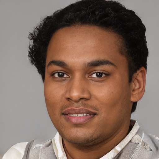 Joyful black young-adult male with short  brown hair and brown eyes