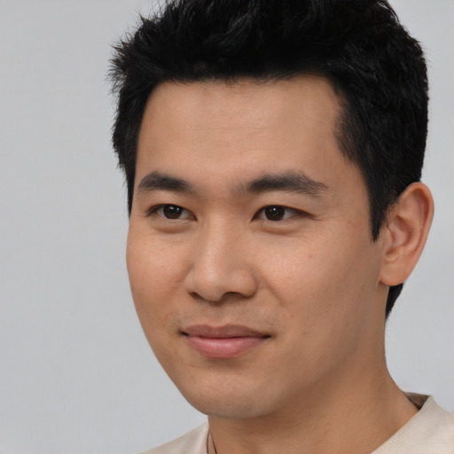 Joyful asian young-adult male with short  black hair and brown eyes