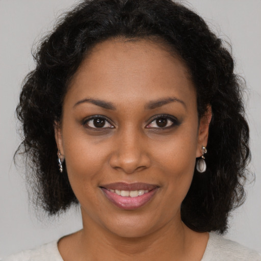 Joyful black young-adult female with medium  brown hair and brown eyes