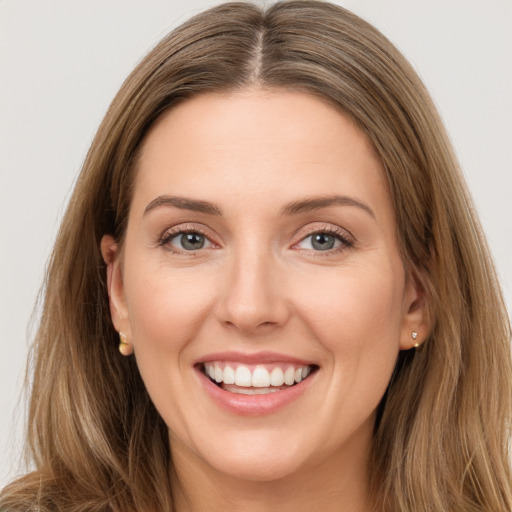 Joyful white young-adult female with long  brown hair and green eyes