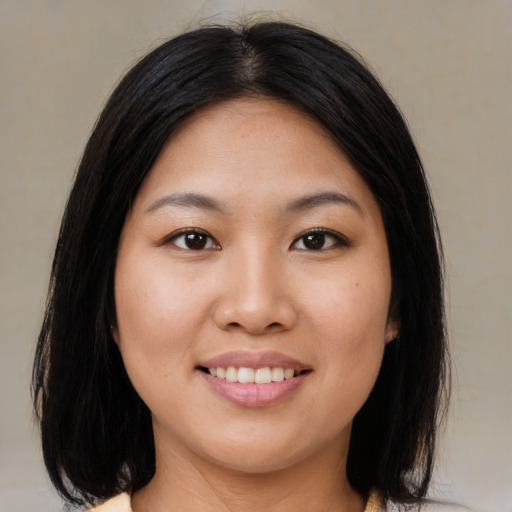 Joyful asian young-adult female with medium  black hair and brown eyes