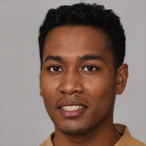 Joyful black young-adult male with short  black hair and brown eyes