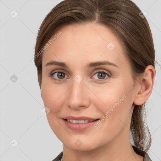 Joyful white young-adult female with medium  brown hair and grey eyes