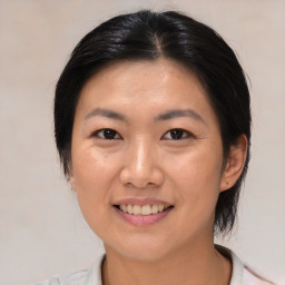 Joyful asian young-adult female with medium  brown hair and brown eyes