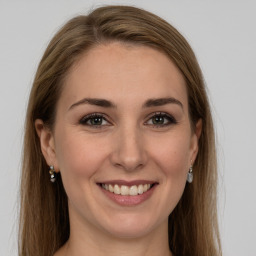 Joyful white young-adult female with long  brown hair and green eyes