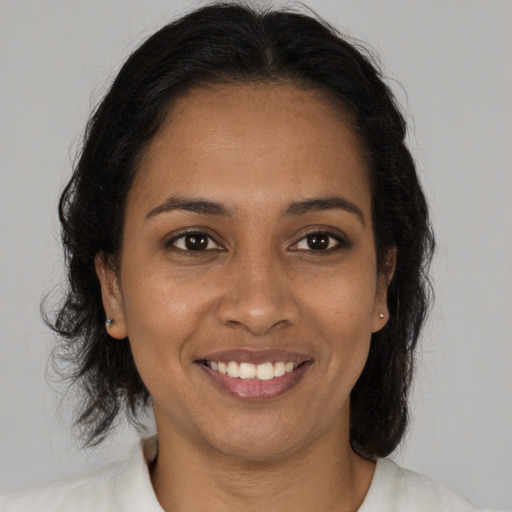 Joyful black young-adult female with long  brown hair and brown eyes