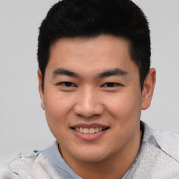 Joyful asian young-adult male with short  black hair and brown eyes